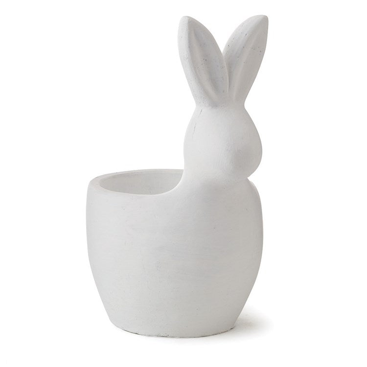 The White Rabbit Cachepot features a smooth surface with long ears and a cylindrical opening, making it perfect for placing plants directly. It's ideal for home or garden decor, combining simplicity with a playful and whimsical aesthetic.